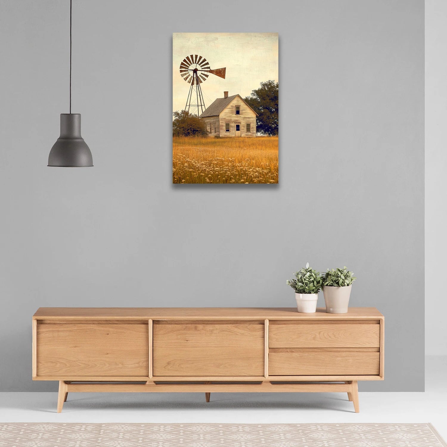 Farmhouse windmill wall art featuring a rustic house and windmill over a golden field hanging above wooden sideboard