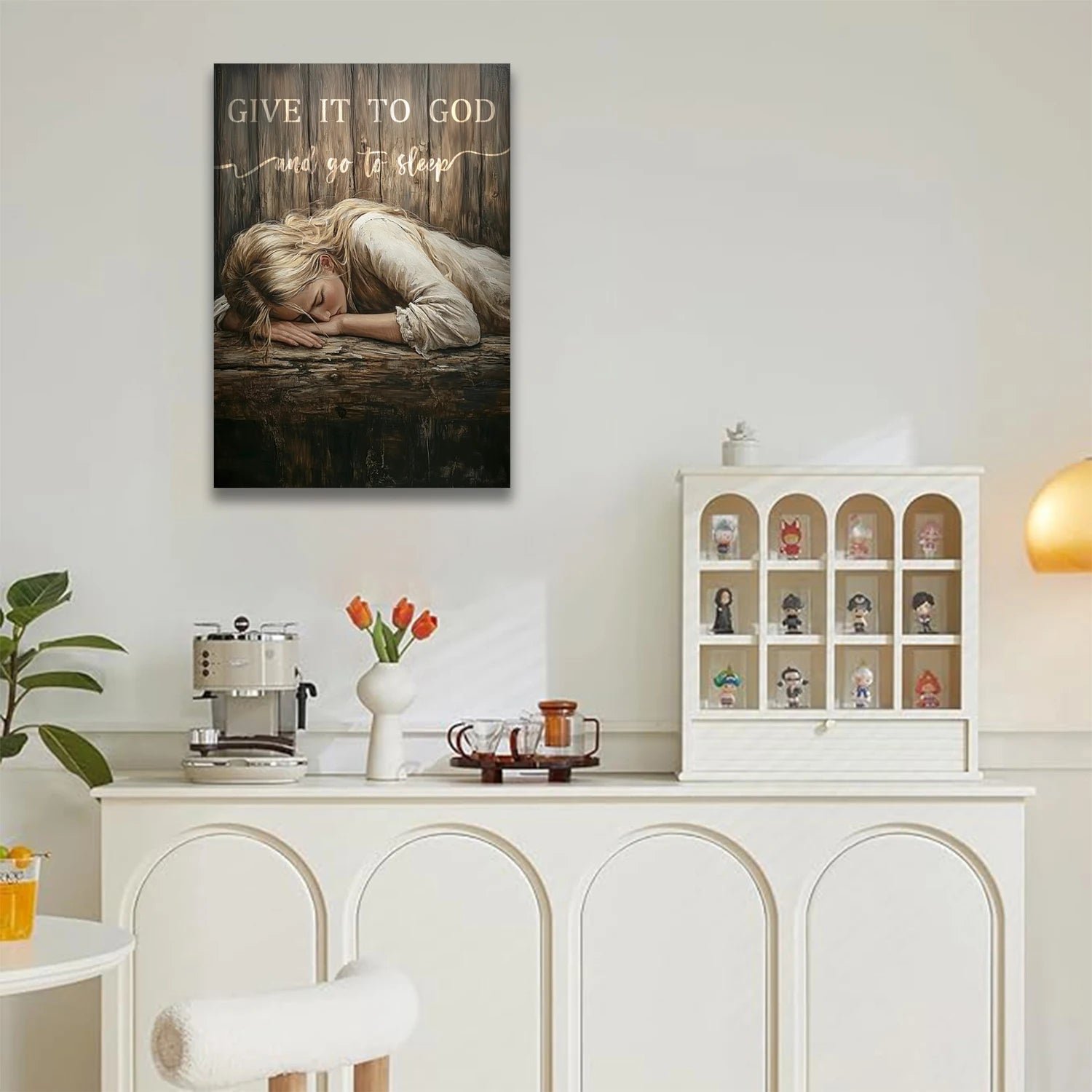 Give It to God wall art featuring a peaceful sleeping child on rustic wooden background hanging above a white sideboard in a modern cozy room