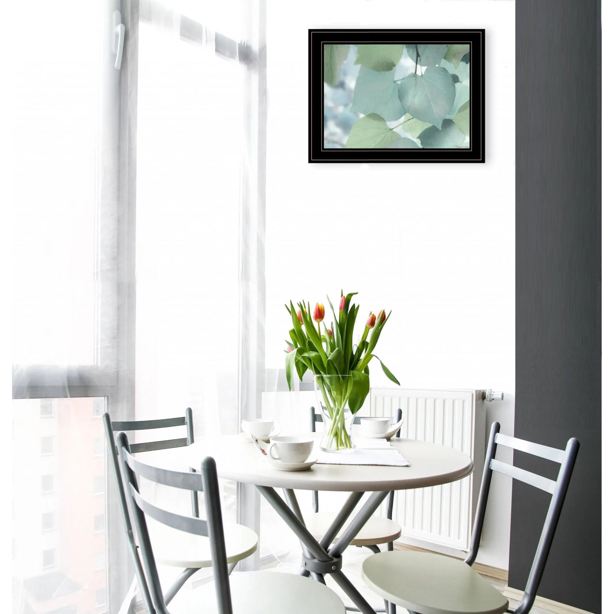 Modern dining room with round table and tulip vase featuring AI generated leaf wall art framed on white wall